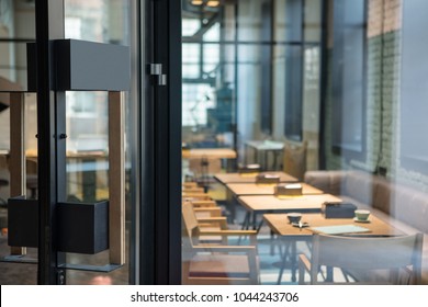 Moderne deurklink op de houten glazen deur voor het café.