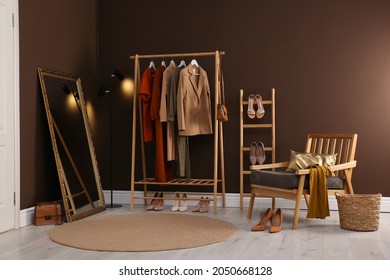 Modern Dressing Room Interior With Clothing Rack, Mirror And Comfortable Armchair