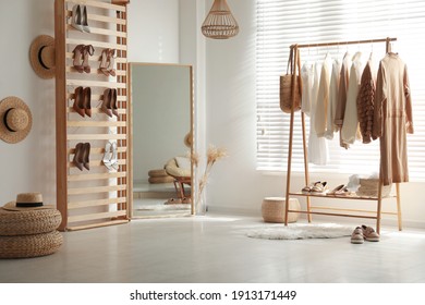 Modern dressing room interior with racks of stylish women's clothes and shoes - Shutterstock ID 1913171449
