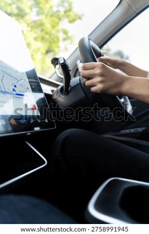 Modern driver using GPS navigation on a large touchscreen in a high-tech electric vehicle. Concept of smart mobility, urban commuting, and future automotive technology. Vertical Shot