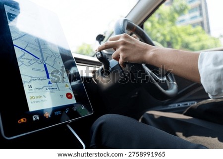 Modern driver using GPS navigation on a large touchscreen in a high-tech electric vehicle. Concept of smart mobility, urban commuting, and future automotive technology.