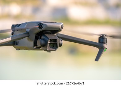 A modern drone of a famous brand with two close-up cameras. The quadcopter is hovering in the air and taking photos.