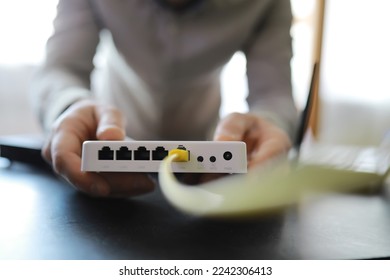 Modern dual band wireless router. Man working in the background. Fast wireless internet concept. - Shutterstock ID 2242306413
