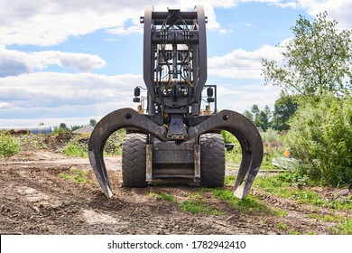 modern dual function grapple skidder stands on the ground outdoors