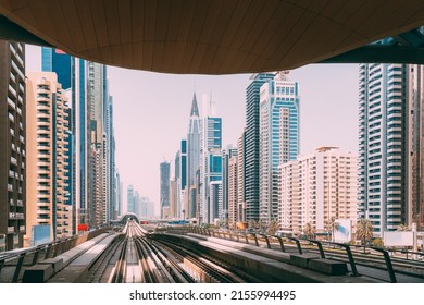 Modern Dubai Metro. Metro railway among glass skyscrapers in Dubai. Traffic on street in Dubai. Urban city background. Modern with skyscrapers architecture of Dubai, UAE.