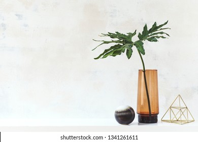 Modern And Eclectic Room Interior With Abstract Wiped Walls, Gold Pyramid And Tropical Leaf In Vase .Stylish Space With Design Accessories. Eclectic Home Decor. Real Photo. Copy Space For Inscription.