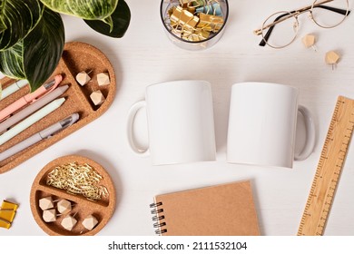 Modern eco friendly desktop with zero waste stationary and white mug mockup. Comfortable working space, sustainable life style concept. Top view, flat lay.