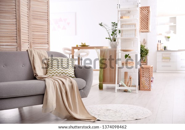 Modern eco style living room interior with wooden\
crates, shelves and sofa