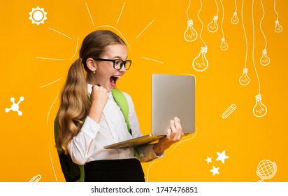 Modern Education Of Children. Overjoyed School Girl With Backpack Is Happy With Test Result, Holds Laptop In Hands, Over Yellow Background In Studio