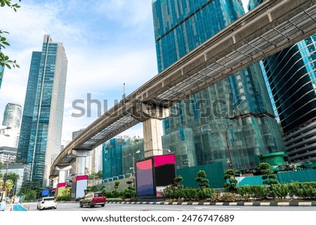 A modern efficient integrated transport network,running atop tall concrete pillars,winding in between modern skyscrapers,connecting many areas of central KL City and its International airport.