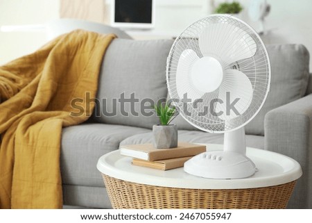 Modern electric fan on coffee table in living room, closeup