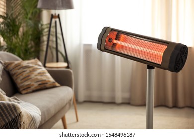 Modern electric infrared heater at home. Space for text