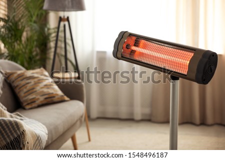 Modern electric infrared heater at home. Space for text