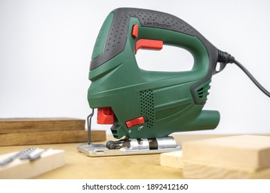 Modern Electric Jig Saw Tool For DIY Home Woodworking. Wood Boards On Background