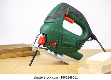 Modern Electric Jig Saw Tool For DIY Home Woodworking. Wood Boards On Background