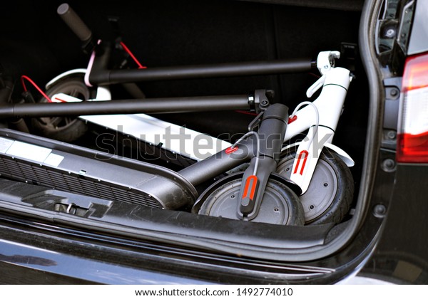 Modern electric\
scooter in the trunk of a\
car.