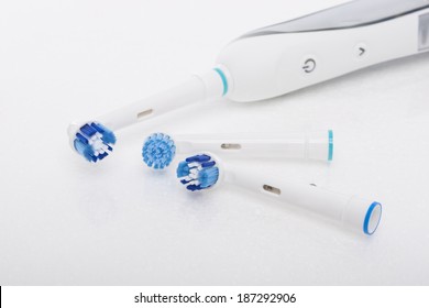 Modern Electric Toothbrush with a Few Spare Heads Together Over white. Horizontal Image