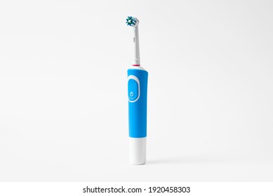 Modern electric toothbrush standing on a white background. Controlled tool for daily oral care.