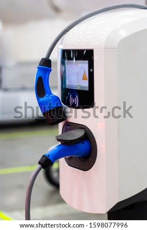 A modern electrical fast charger for the electrical or hybrid PHEV automobiles. An Energy power of future. Ecology friendly charger concept. Home electric car battery charger.