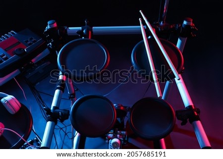 Modern electronic drum kit on dark background, color toned. Musical instrument