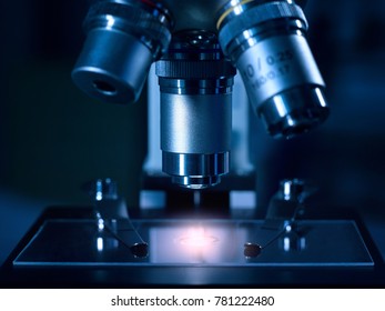 A Modern Electronic-optical Device, A Microscope, Against The Background Of A Set Of Test Tubes For Research. High Resolution Studio Image. High Tech Background.