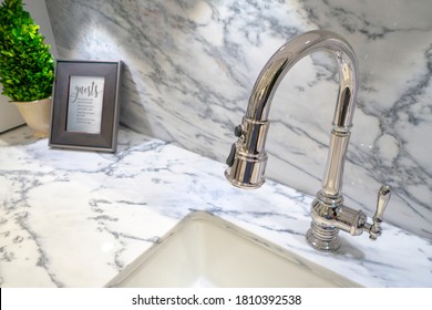 Modern Elegant  Silver Chrome Kitchen Faucet With Pull Down Sprayer All In One With Small Plant And Frame On Marble Counter Top