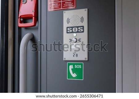 Modern emergency call point and intercom with illuminated SOS button inside a train, offering crucial passenger communication and safety during transit
