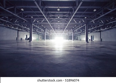 Modern empty dark storehouse with light at the end