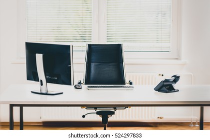 Modern Empty Office Space Desk With Computer, Phone And Chair. Concept Of Corporate Job Vacancy, Promotion, Financial World And Business In General.