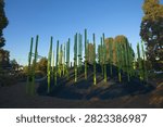 Modern empty playground featuring bright green climbing poles embedded in sculpted rubber mounds at Stockade Park in Aintree, Victoria, Australia.