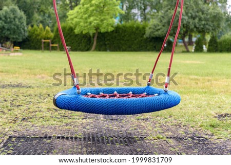 Modern empty swing made of ropes on the playground