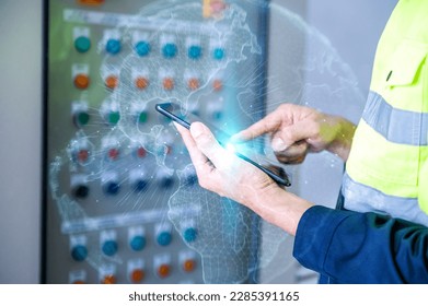 Modern engineer with tablet using laptop in server room while inspecting server in asian power plant, modern technology perspective