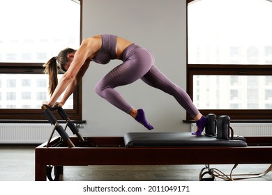 Modern equipment studio reformer for Pilates in the gym, Concept of recovery and rehabilitation, the instructor performs exercises on the studio reformer to correct the musculoskeletal system.