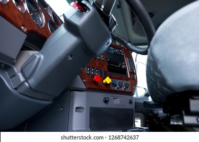 Modern Ergonomic Dashboard Of Heavy Semi Truck With Lots Of Equipment, Steering Column, Indicators, Buttons, And Other Electronics, Decorated With Plastic Imitation Wood, Integrated Into The Interior 