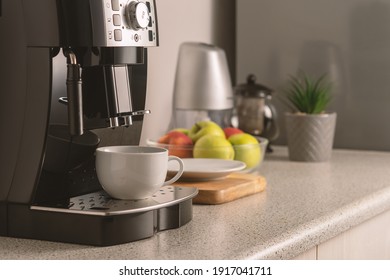 Modern espresso coffee machine with a cup in interior of kitchen closeup.