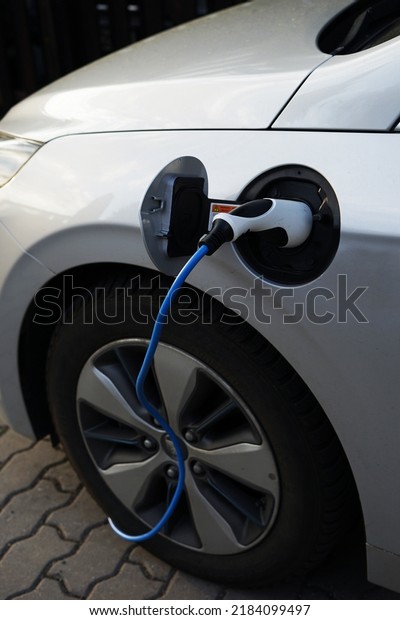 Modern EV electric car\
charging at home using green electric energy, future of transport\
concept