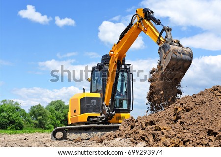 The modern excavator performs excavation work on the construction site 