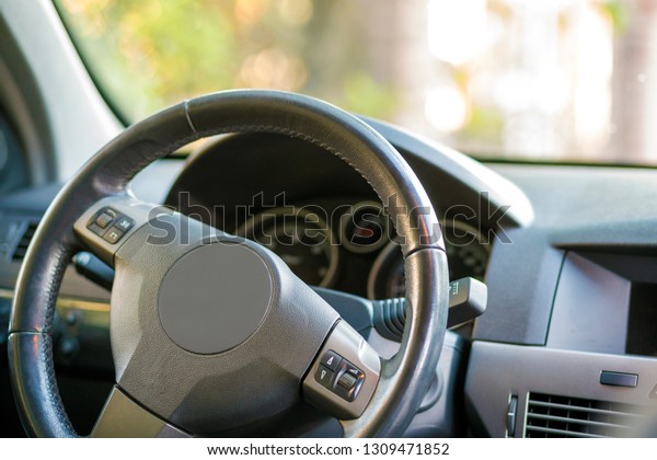 Modern expensive car black luxurious interior.\
Steering wheel, dashboard, windshield and mirror. Transportation,\
design, modern technology\
concept.
