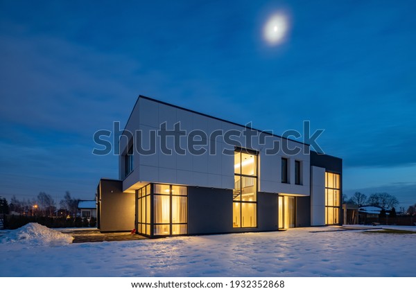 Modern exterior of luxury cottage.\
Private house in scandinavian style at winter\
evening.