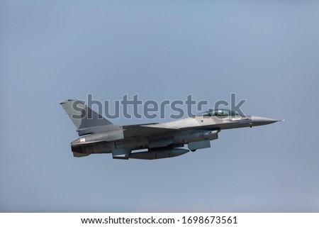 Modern F-16 Fighter Plane Above the Clouds 