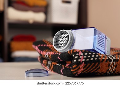 Modern fabric shaver and cloth on white table indoors, closeup. Space for text - Shutterstock ID 2257367775