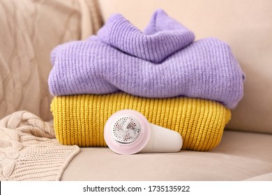 Modern fabric shaver and clothes on sofa