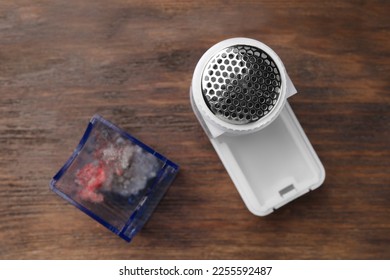 Modern fabric shaver with fuzz on wooden table, flat lay - Shutterstock ID 2255592487