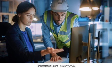 Modern Factory Office: Male Project Manager Talks to a Female Industrial Engineer who Works on Computer. Professional Teamwork, Specialists Solving Problems, Finding Solutions - Shutterstock ID 1936499926