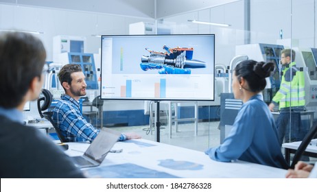 Modern Factory Office Meeting Room: Diverse Team Of Engineers, Managers And Investors Talking At Conference Table, Watching Interactive TV That Shows Sustainable And Renewable Green Energy Engine