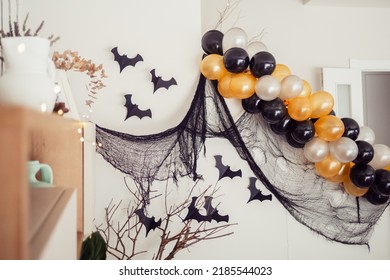 Modern fall home decor for Halloween party with orange balloons, bats and black chiffon. - Powered by Shutterstock