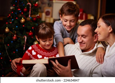 Modern Family Of Four Reading Christmas Fairy Tales