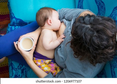 Modern family lifestyle. Aerial view of a woman giving baby breastfeeding having a coffee