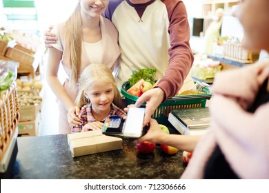 Modern Family Making Contactless Payment At Supermarket Cash-register