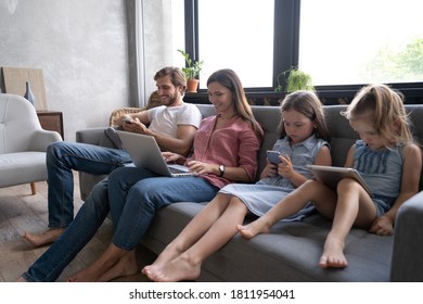 Moderne Familienwerte. Vater, Mutter und Töchter mit elektronischen Geräten